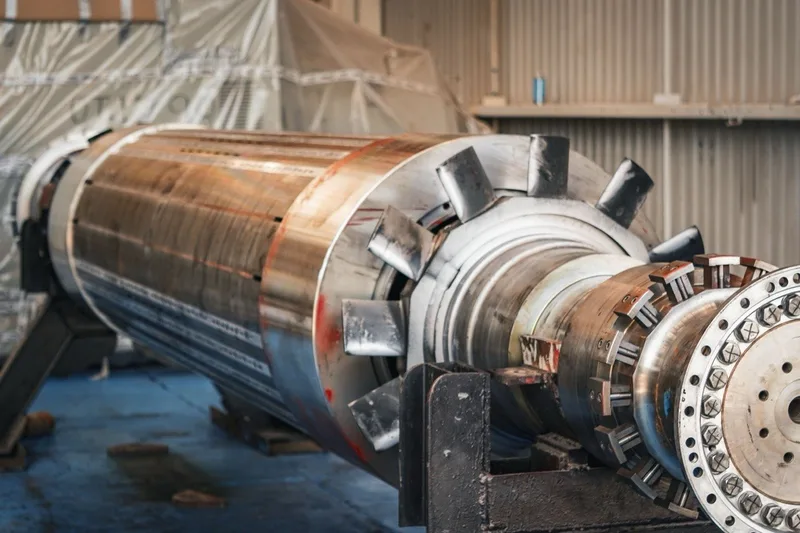 A large machined steel rotor in a heavy-engineering workshop.