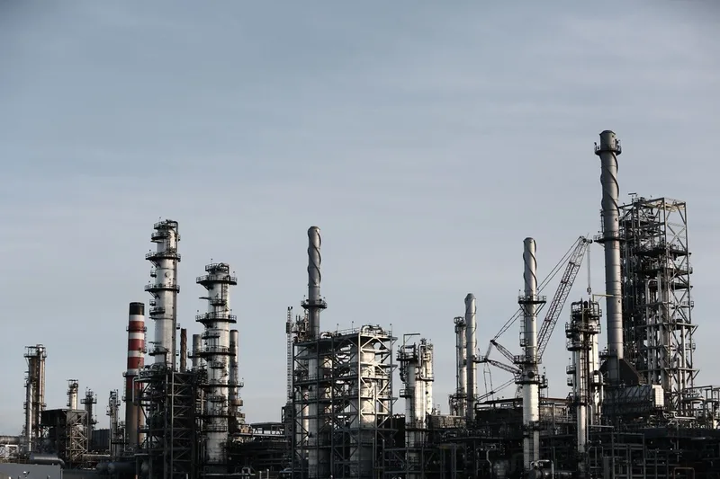 Refinery columns and process units against an overcast sky.